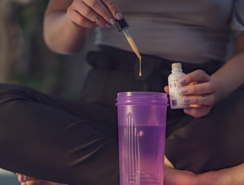 Woman adding her water-soluble CBD into a shaker cup